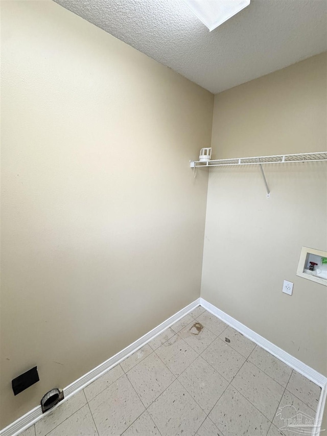 washroom with washer hookup and a textured ceiling