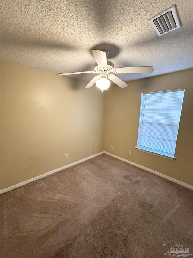 empty room with a textured ceiling, ceiling fan, and carpet