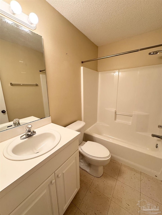 full bathroom featuring bathing tub / shower combination, vanity, a textured ceiling, tile patterned floors, and toilet