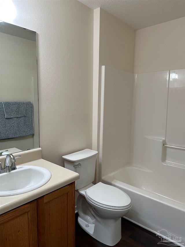 full bathroom featuring a textured ceiling, vanity, toilet, and tub / shower combination