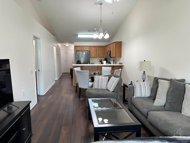 living room featuring dark hardwood / wood-style floors, lofted ceiling, and a chandelier