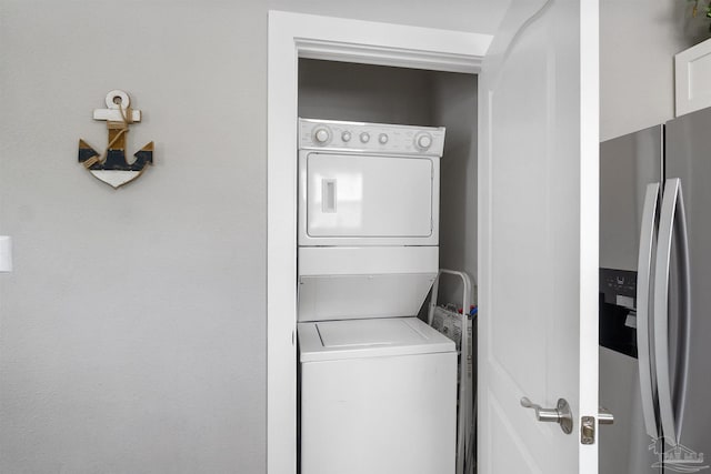 washroom featuring stacked washer and dryer and laundry area