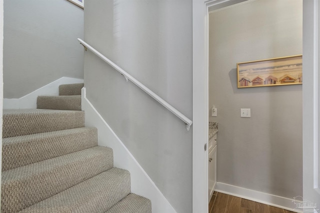 staircase with wood finished floors and baseboards