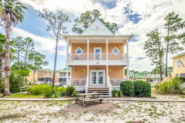 view of front of home featuring covered porch, french doors, and a balcony