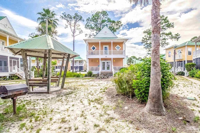 rear view of property featuring french doors and a balcony