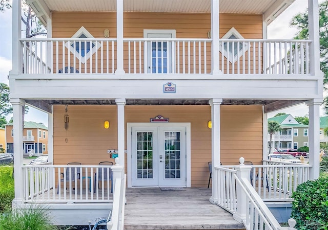 property entrance with covered porch and french doors