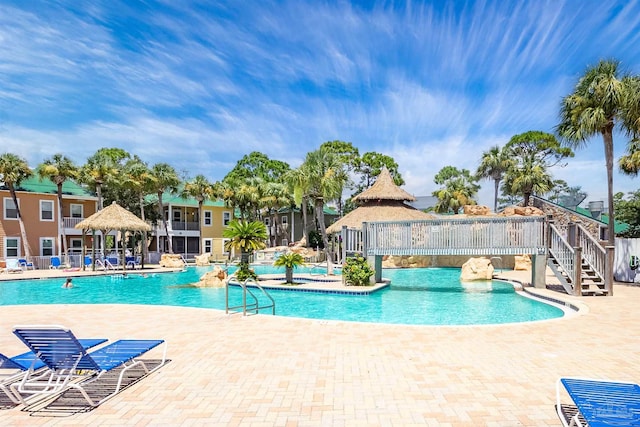 community pool with a patio and fence