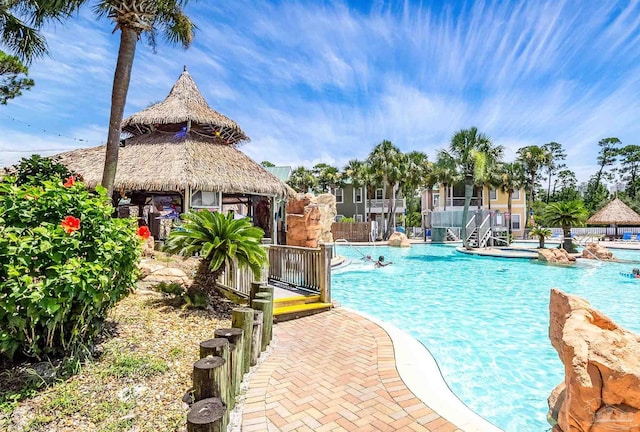 community pool featuring fence, a gazebo, and a patio