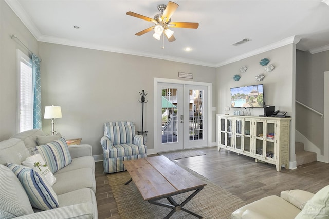 living area featuring wood finished floors, visible vents, stairs, french doors, and crown molding