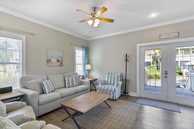 living room with a healthy amount of sunlight, crown molding, and wood finished floors