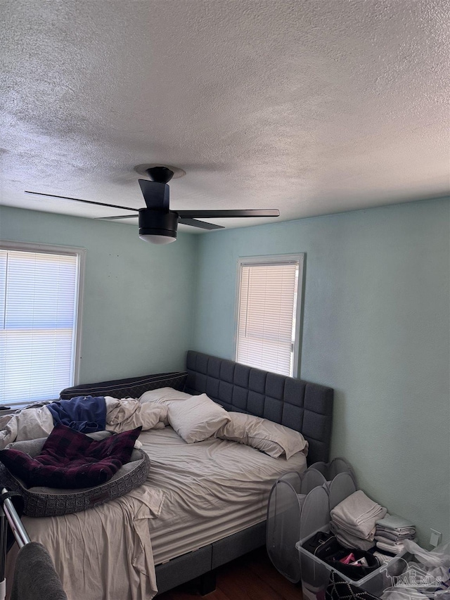 bedroom featuring multiple windows, ceiling fan, and wood finished floors