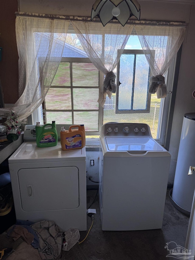 washroom with water heater, laundry area, and washer and clothes dryer