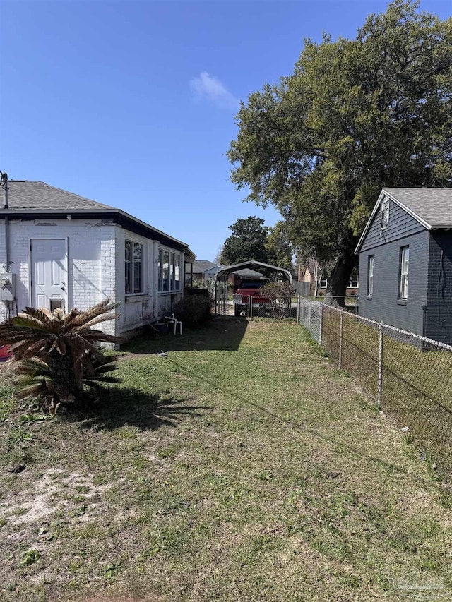 view of yard featuring a detached carport and fence