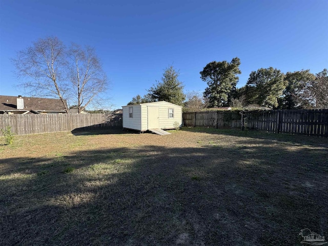 view of yard with an outbuilding, a storage shed, and a fenced backyard