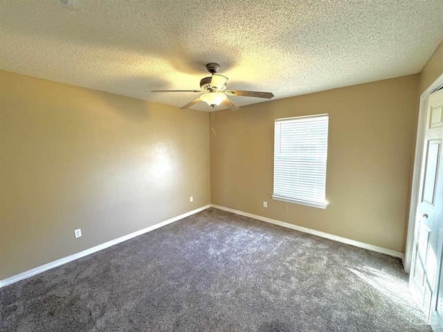 empty room featuring a textured ceiling, ceiling fan, dark carpet, and baseboards