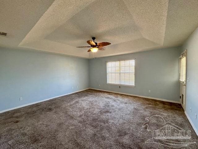 unfurnished room with ceiling fan, carpet floors, a textured ceiling, and a tray ceiling