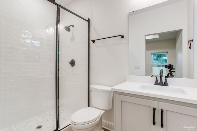 bathroom with vanity, toilet, and a shower stall