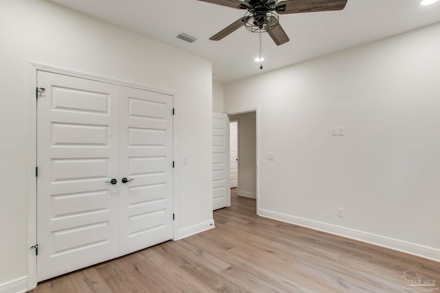 unfurnished bedroom with a ceiling fan, visible vents, baseboards, light wood-style flooring, and a closet