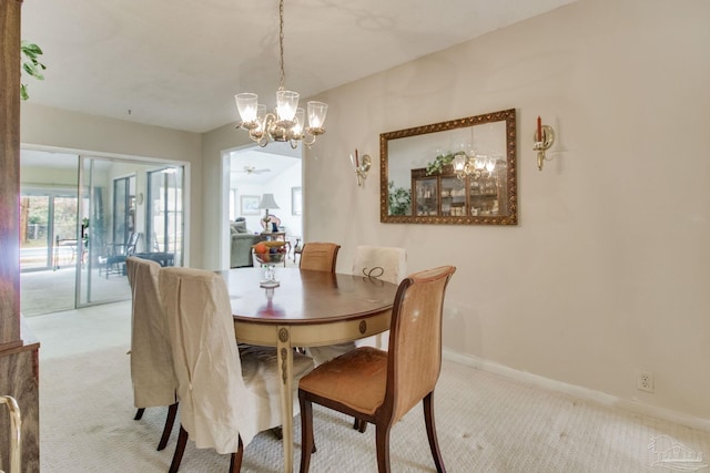 dining space featuring light carpet and baseboards