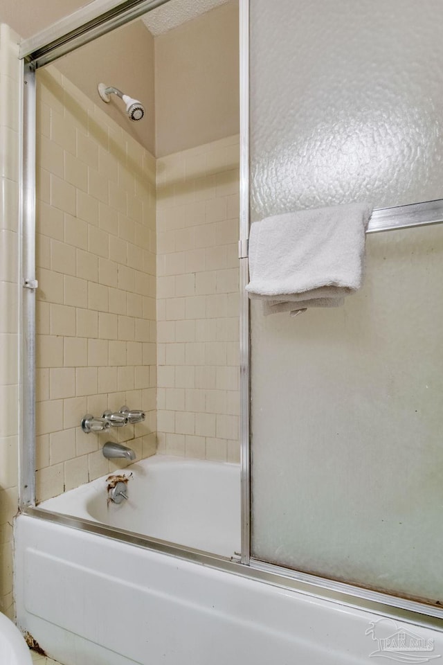 bathroom with bath / shower combo with glass door