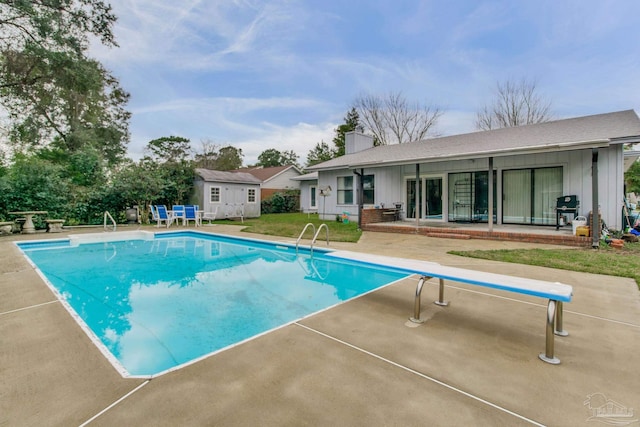 outdoor pool with an outbuilding, a yard, a patio area, and area for grilling