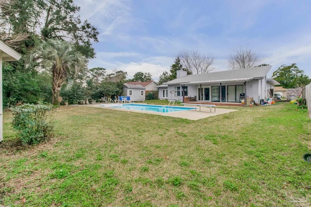 back of house featuring an outdoor pool, a chimney, fence, a yard, and a patio area