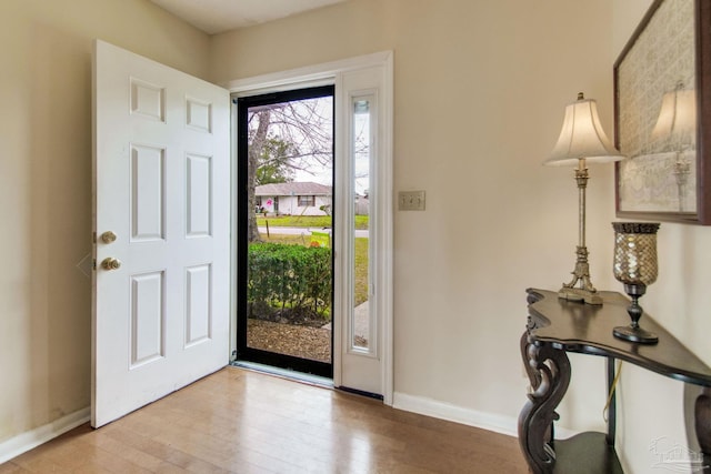 foyer featuring light wood-style flooring and baseboards