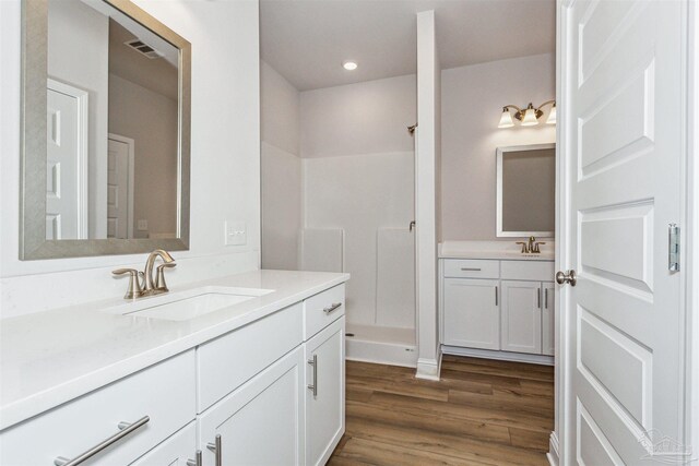 bathroom featuring walk in shower, wood-type flooring, and vanity