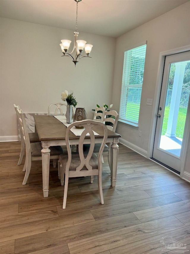 dining area with an inviting chandelier and light wood-type flooring