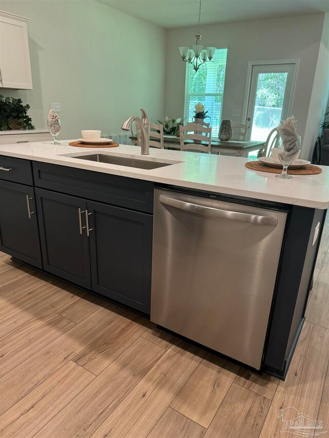 kitchen featuring sink, dishwasher, white cabinetry, an inviting chandelier, and decorative light fixtures