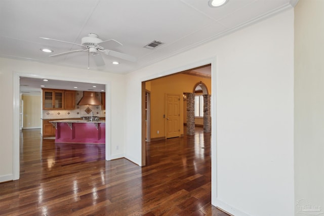 interior space featuring dark wood-type flooring, ceiling fan, and crown molding