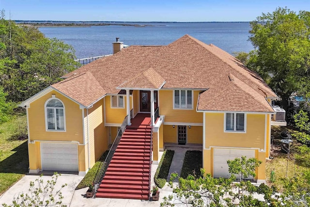 view of front of house featuring a garage and a water view