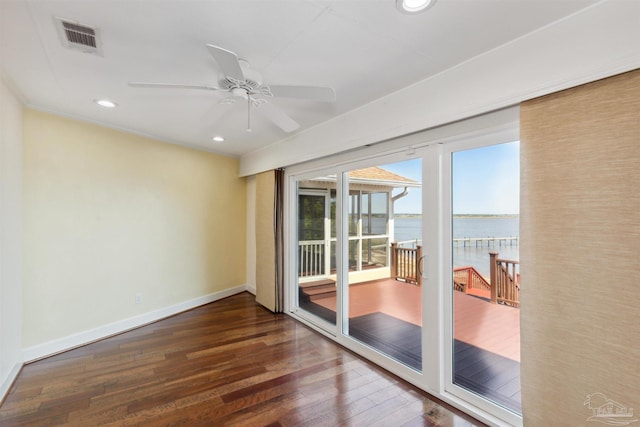 doorway with a water view, ceiling fan, and dark wood-type flooring