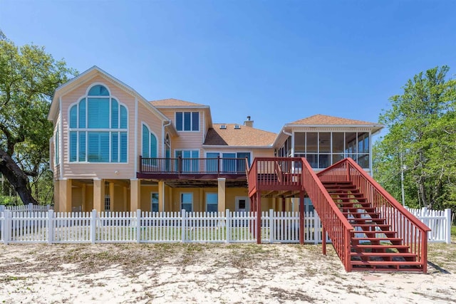 back of property with a deck and a sunroom