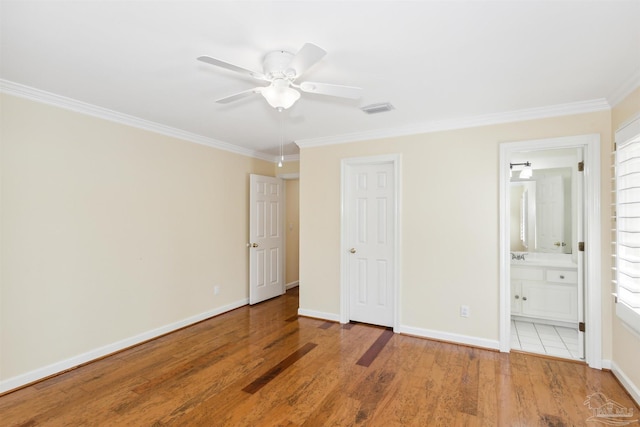 unfurnished bedroom featuring crown molding, light hardwood / wood-style flooring, and ensuite bathroom