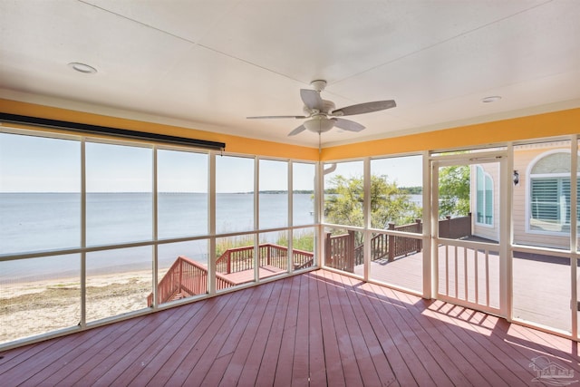 unfurnished sunroom with a water view and ceiling fan