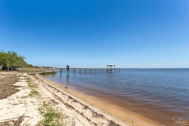 dock area featuring a water view and a beach view