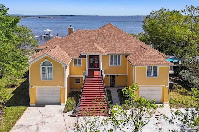 view of front of house featuring a garage and a water view