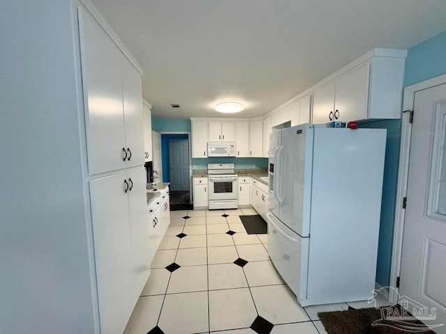 kitchen with white cabinets, white appliances, and light tile patterned floors