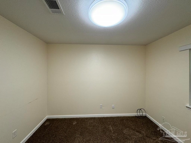 empty room with carpet flooring and a textured ceiling