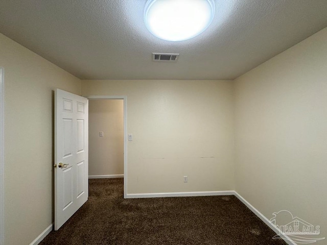 carpeted empty room featuring a textured ceiling