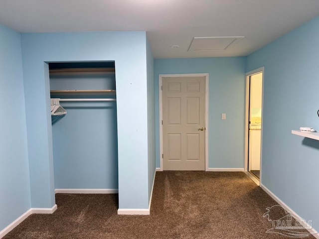 unfurnished bedroom with a closet and dark colored carpet