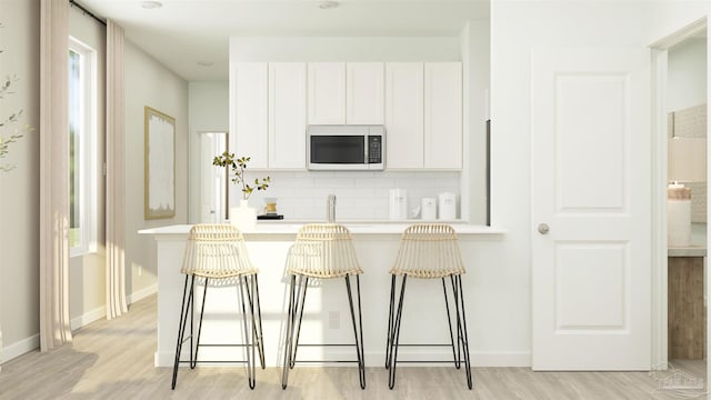 6377 Buckthorn Cir Lot 14E, Pace, FL 32571 - kitchen featuring white microwave, decorative backsplash, white cabinetry, a breakfast bar area, and light countertops