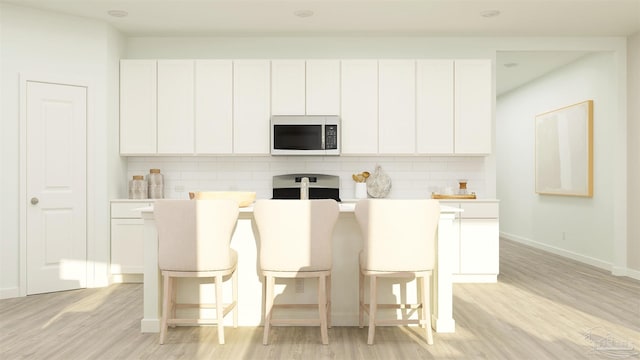 6377 Buckthorn Cir Lot 14E, Pace, FL 32571 - kitchen with white microwave, stove, light wood-type flooring, tasteful backsplash, and white cabinetry