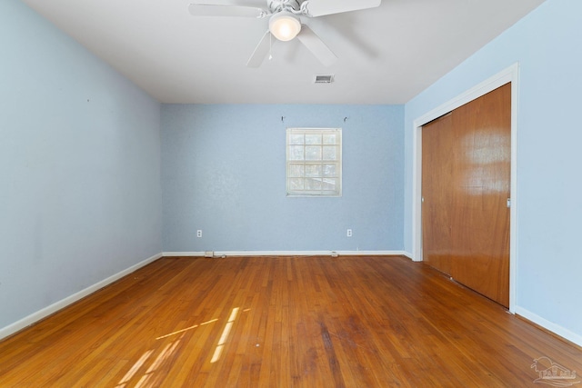 unfurnished bedroom featuring hardwood / wood-style flooring, a closet, and ceiling fan