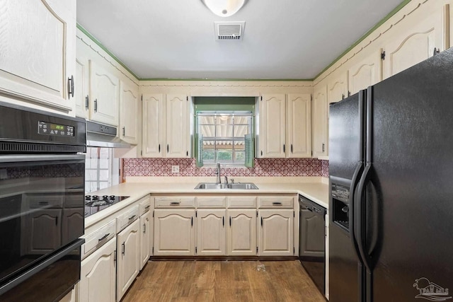 kitchen featuring sink, light hardwood / wood-style flooring, and black appliances