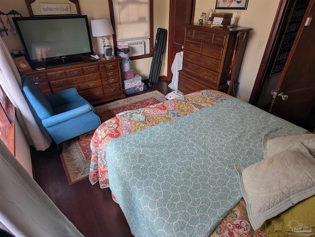 bedroom with cooling unit and wood finished floors