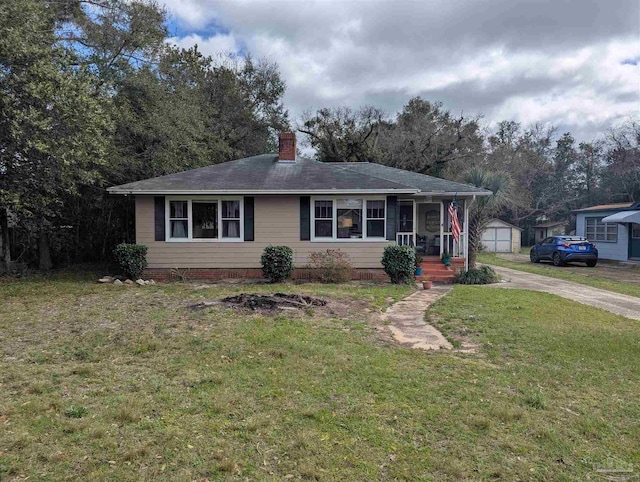 view of front of house featuring a chimney, an outdoor structure, and a front yard