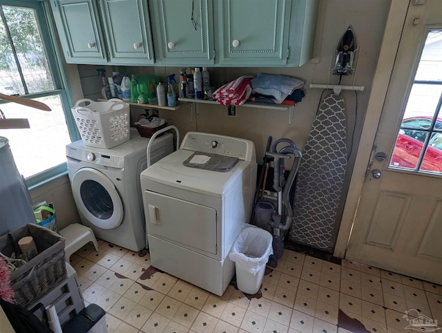 laundry room featuring cabinet space, separate washer and dryer, and light floors