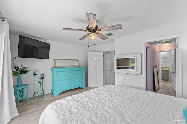 bedroom with ceiling fan, connected bathroom, and light hardwood / wood-style flooring